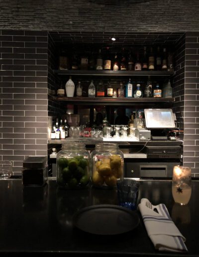 A bar with jars of lemons on the counter.