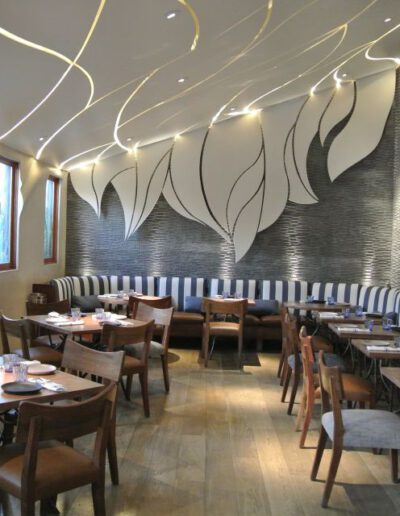 The interior of a restaurant with a large mural on the wall.