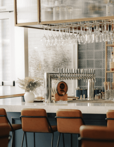 A bar in a restaurant with a lot of wine glasses.