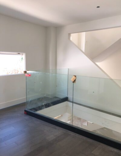 A room with a glass railing and stairs.