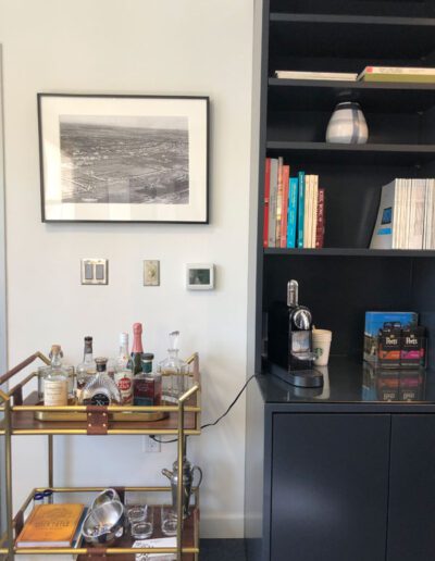 A bar cart in a room with a book shelf.