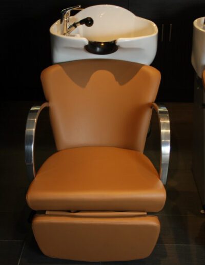 Two chairs in a salon with a sink in the middle.