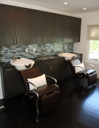 A bathroom with two chairs and a sink.