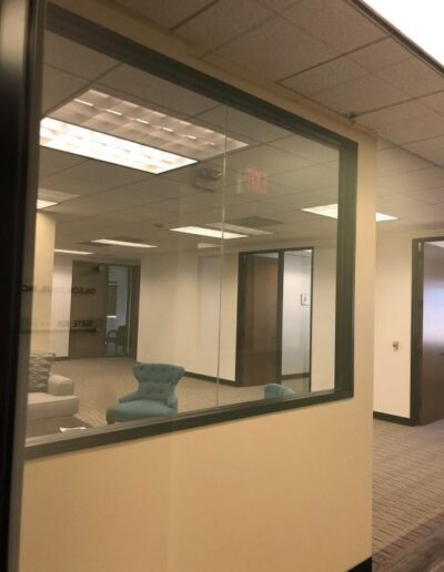 An empty office with a glass wall and chairs.