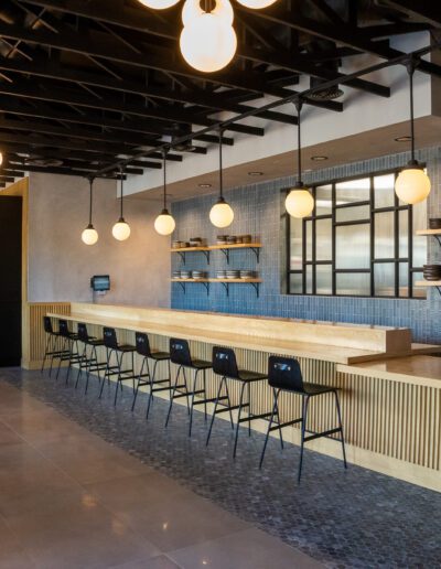 The interior of a restaurant with a bar and stools.