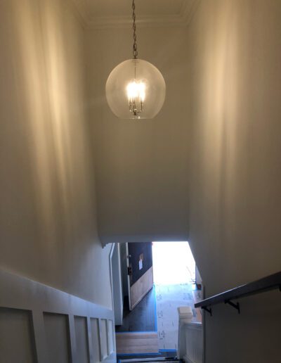 A stairway with a light hanging above it.