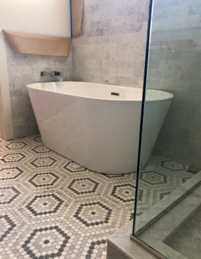 A bathroom with a bathtub and tiled floor.