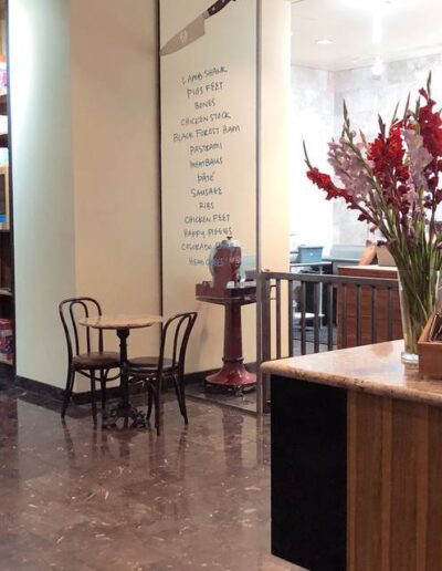 A coffee shop with flowers in a vase.