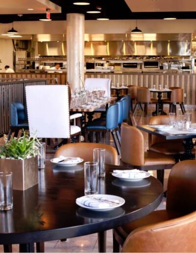 A restaurant with tables and chairs and a chandelier.