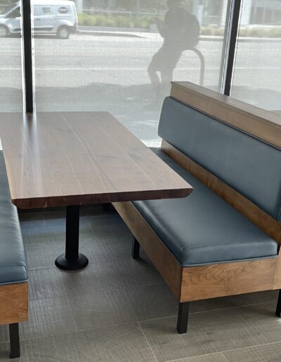 A set of tables and benches in a restaurant.