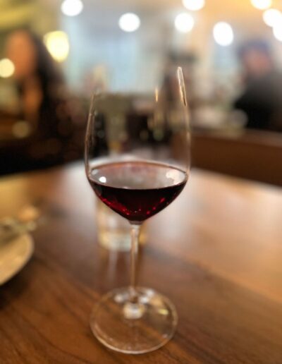 A glass of red wine on a wooden table.