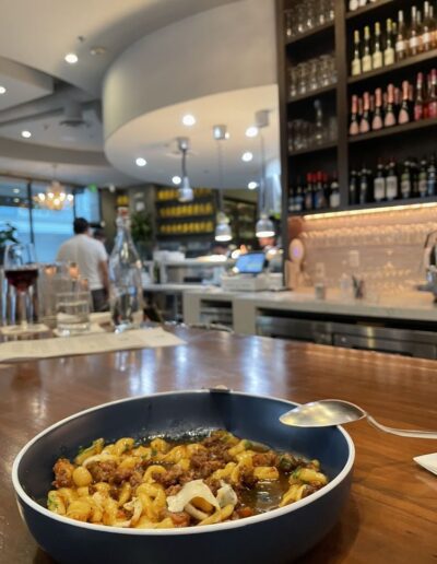 A bowl of pasta on a table in a bar.