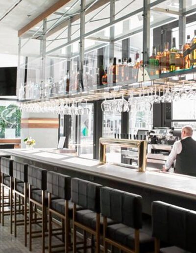 A bar in a restaurant with a glass wall.