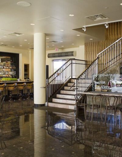 A restaurant with a staircase and a bar.