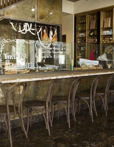 A bar with stools in front of a staircase.