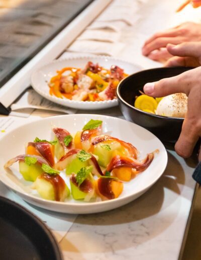 A person reaches for a plate of food on a counter.