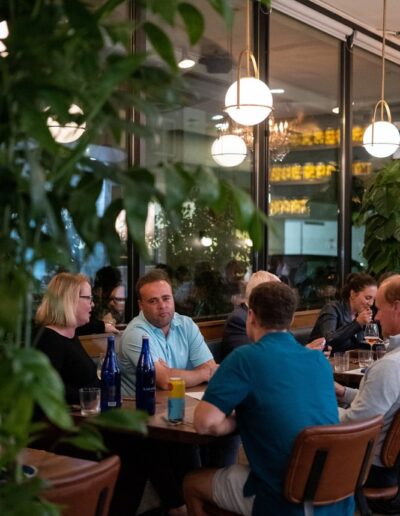 A group of people sitting at tables in a restaurant.