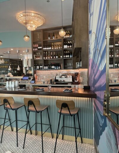 The interior of a restaurant with a bar and stools.