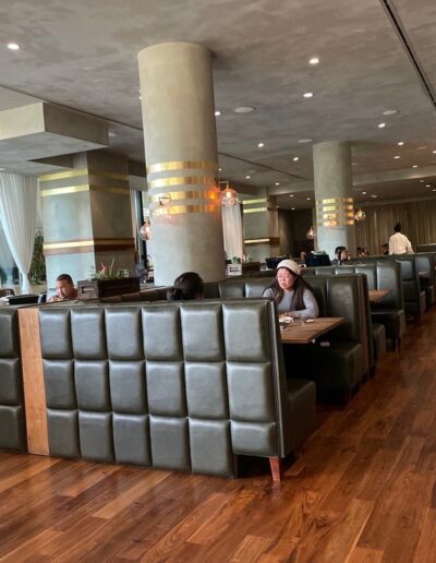 The inside of a restaurant with people sitting at tables.