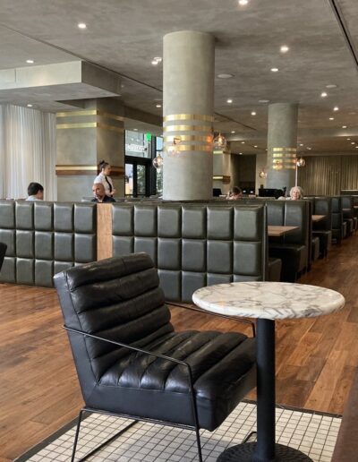 The interior of a restaurant with leather chairs and tables.