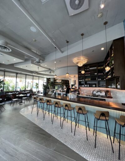 The interior of a restaurant with a bar and stools.